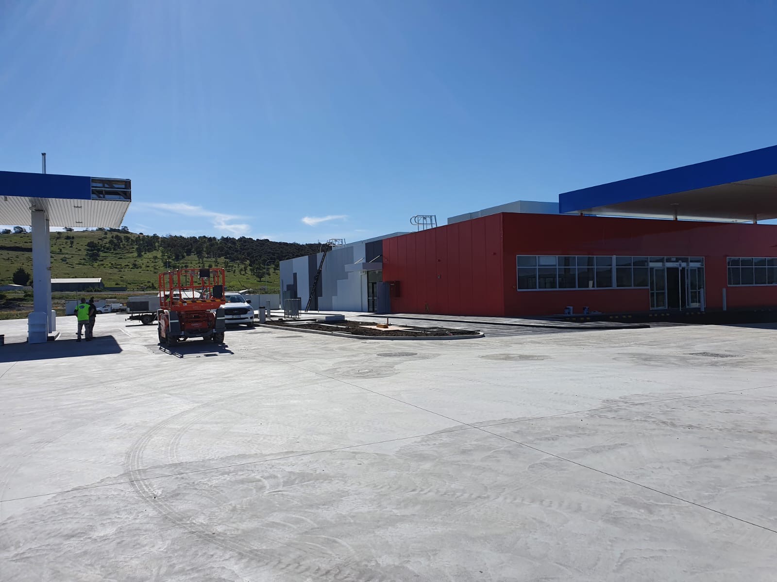 Newly built service station with red and grey cladding, painted by BPM Group